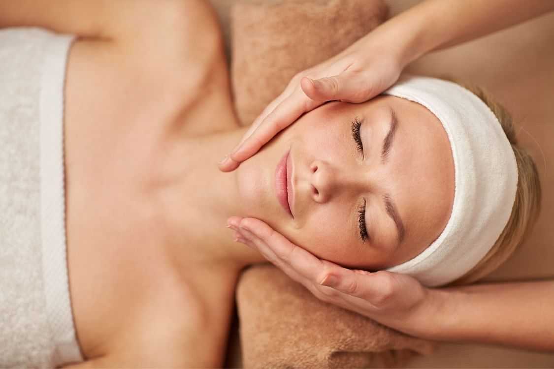 Woman receiving a relaxing facial massage at a spa.