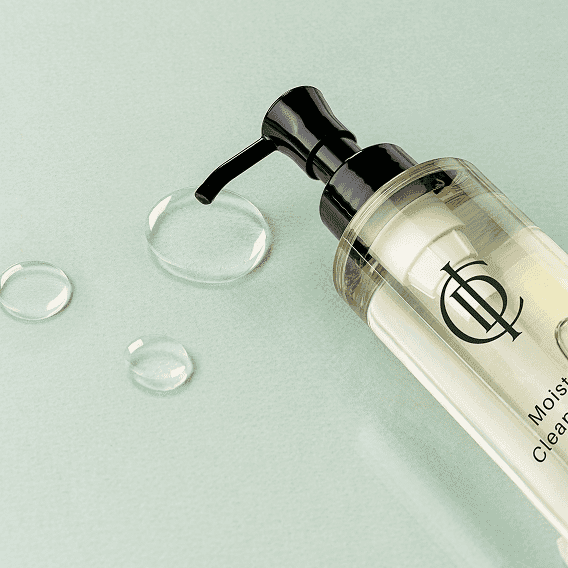 Moisturizing cleanser bottle on a light green surface with water drops.