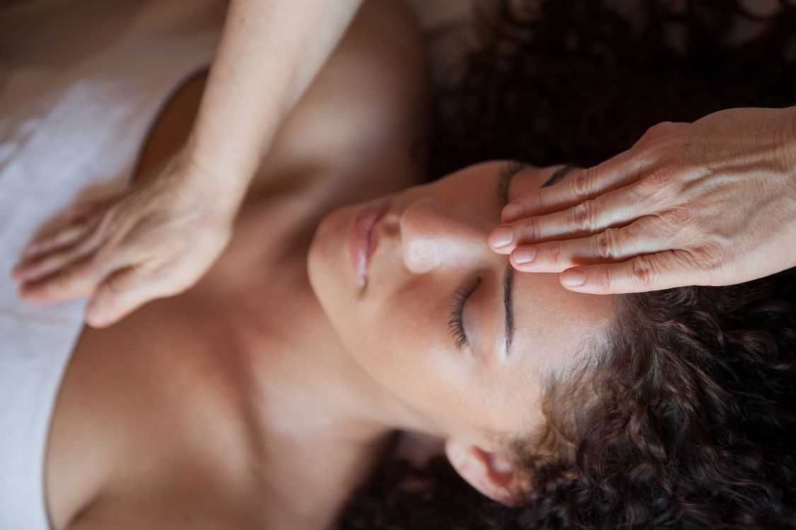 Woman receiving a forehead massage at a spa.