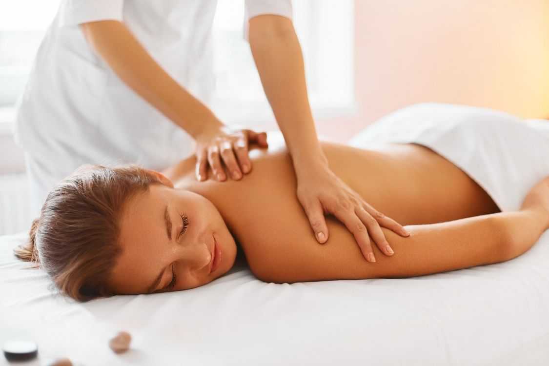 Woman receiving a back massage at a spa.